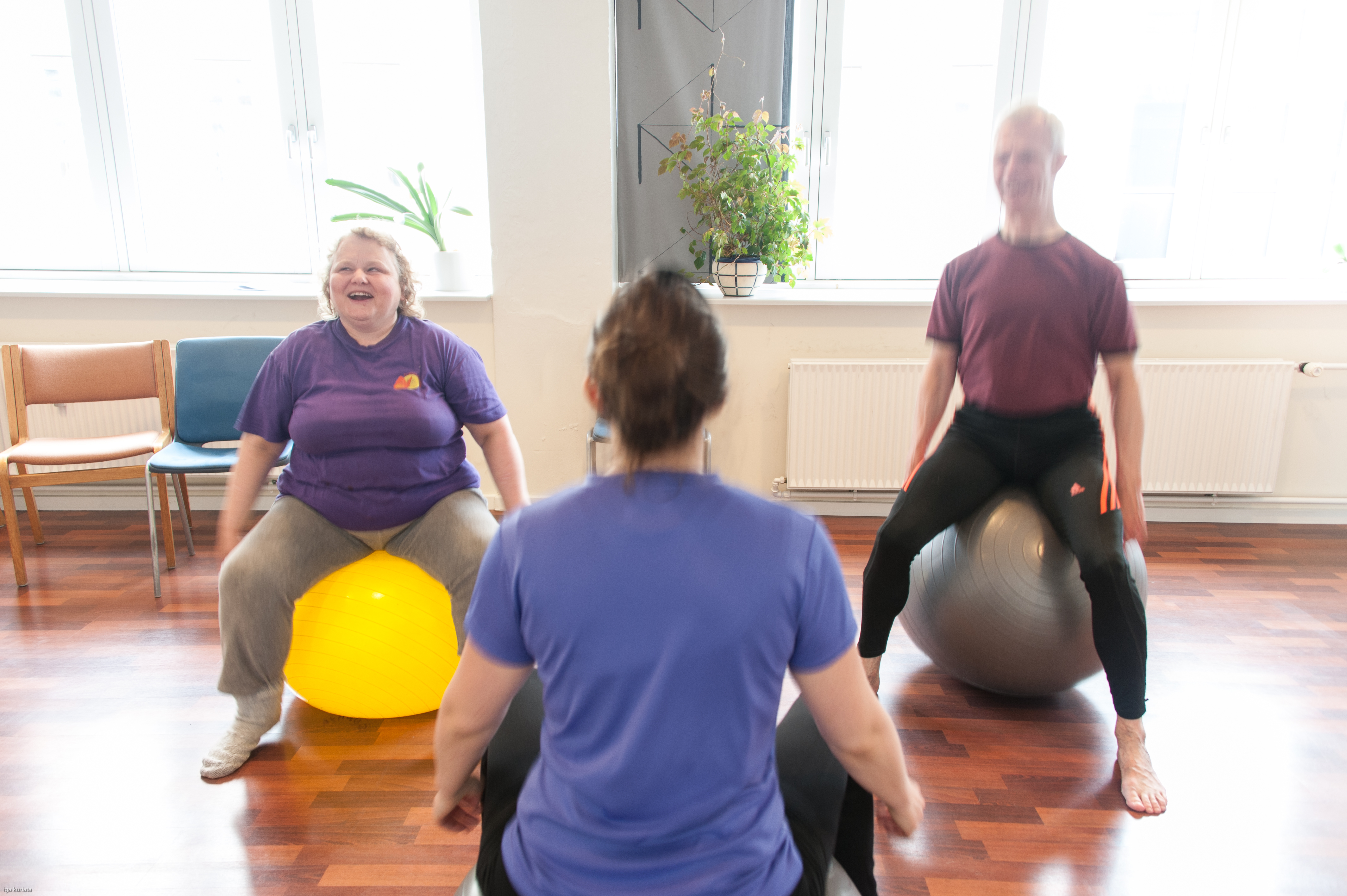 Foto af tre kursister, der laver øvelser på bold.